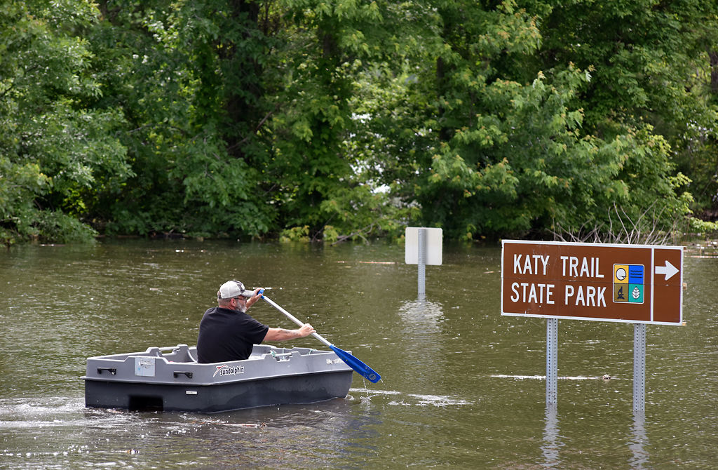 A resident of McBaine paddles through the flooded town